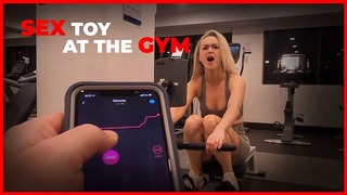 Heißes Babe trainiert mit Fernherrschafts-Sexspielzeug im öffentlichen Fitnessstudio